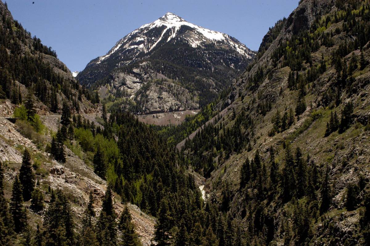 The town of Ouray sits beneath steep green and rocky walls in the San Juan Mountains.