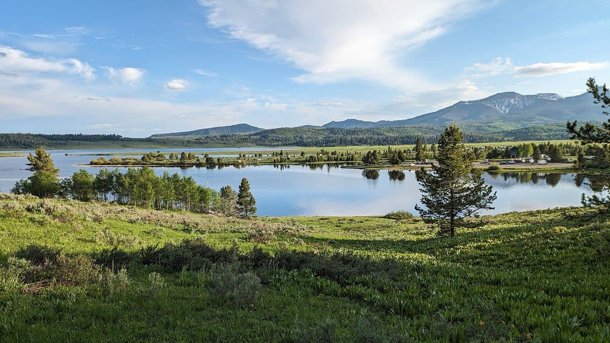 Steamboat Lake and its tree-lined north shore, with Dutch Hill Campground and a broad mountain ridge beyond.