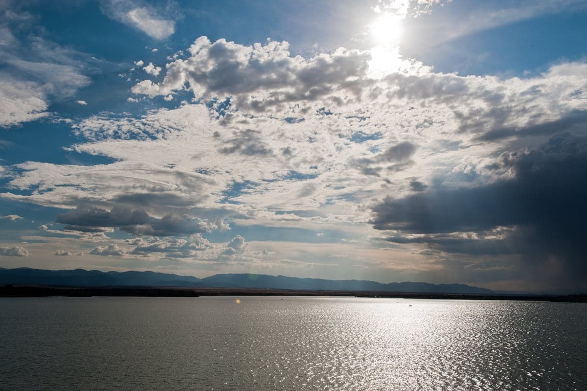 Late-afternoon sun and dramatic clouds reflected across Lake Pueblo.
