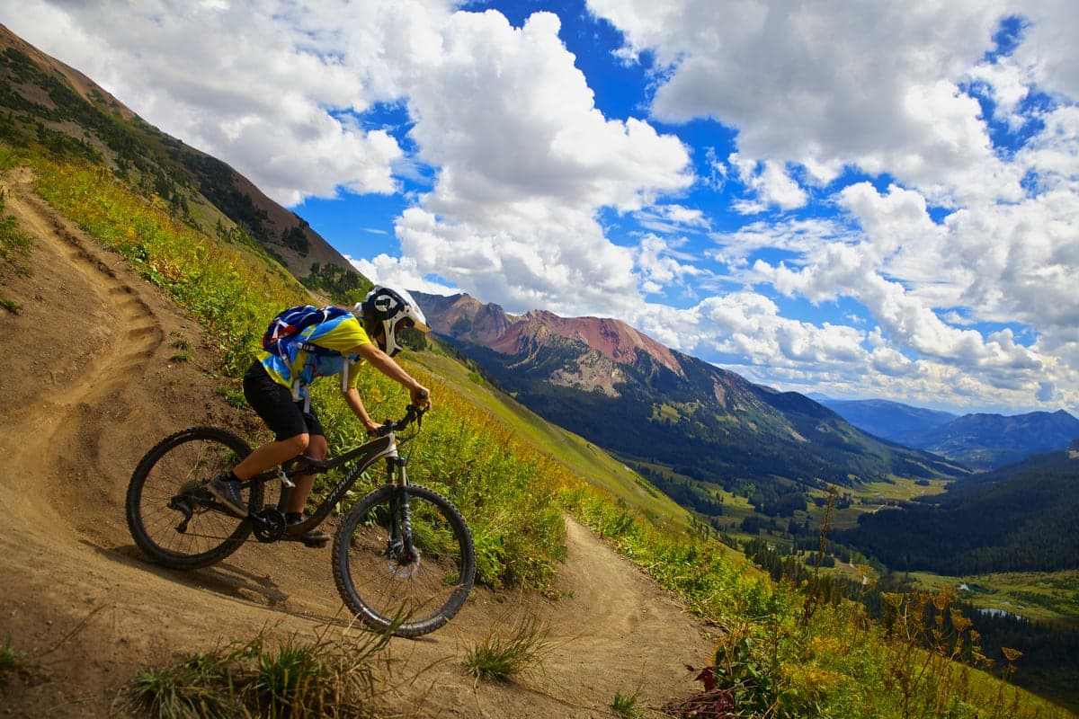Mountain biker descending Trail 401 above Crested Butte and its surrounding peaks.