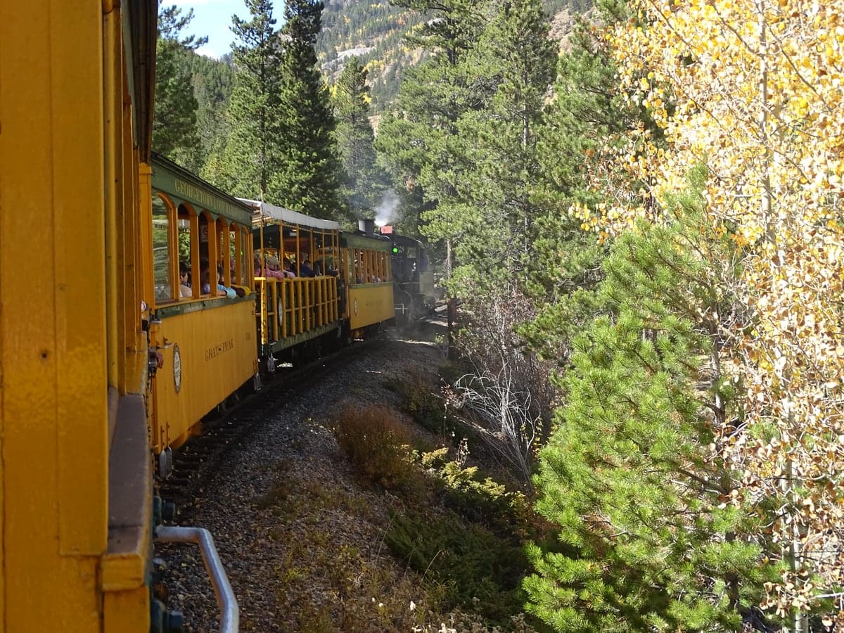 The Georgetown Loop Railroad winds through a forest bright with autumn color.