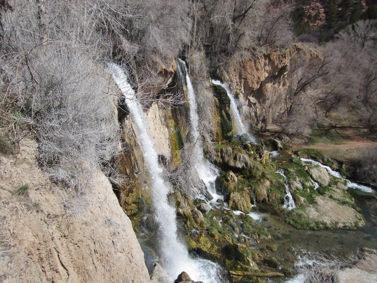 Three green-framed cascades spill over the limestone cliff at Rifle Falls.