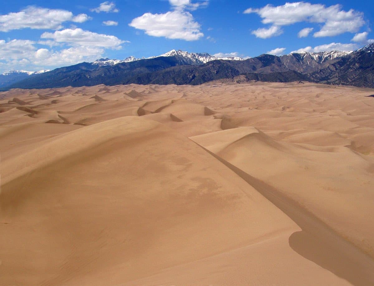 Sunlit ridges of Star Dune rise against the San Luis Valley sky.