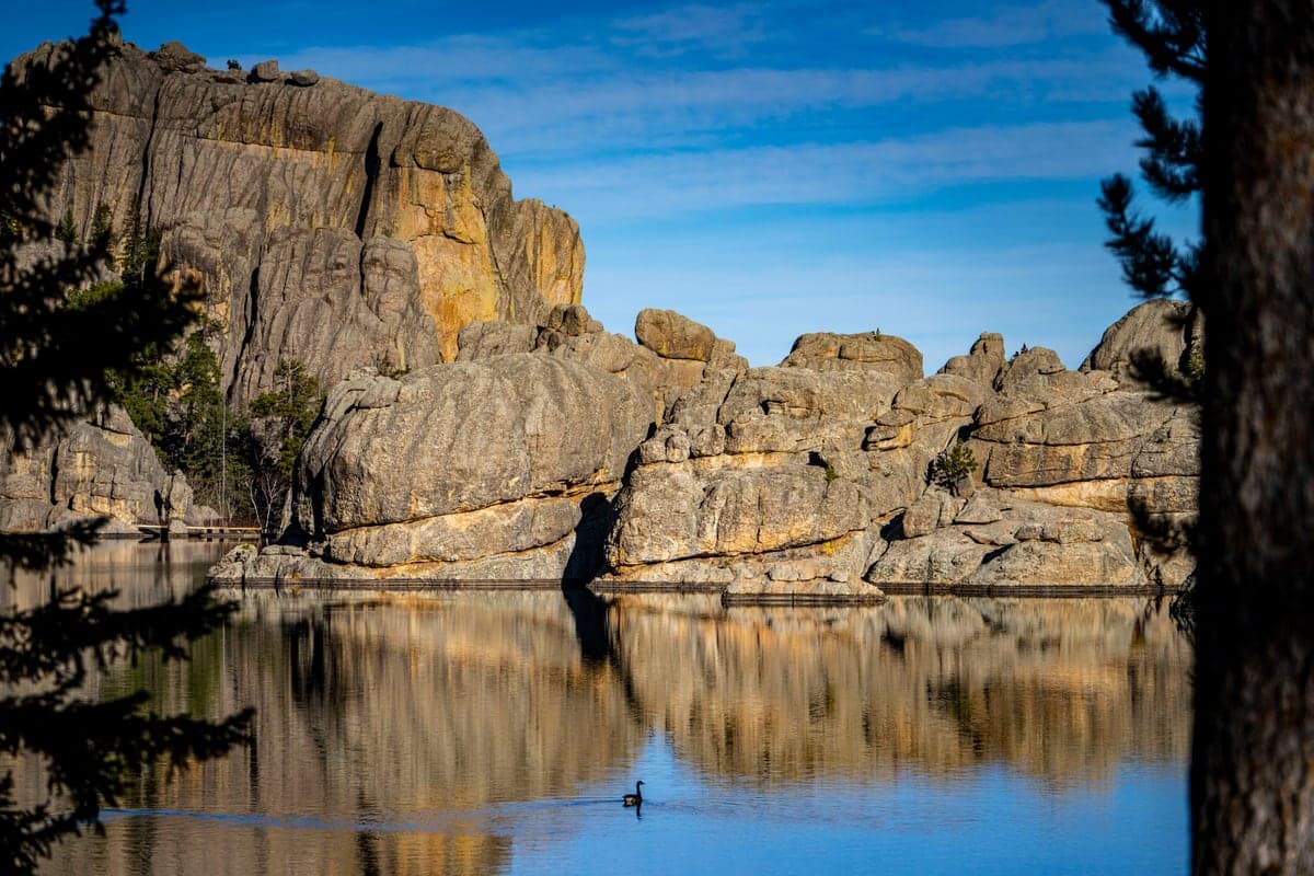 Granite formations reflected in a calm lake in the southern Black Hills.