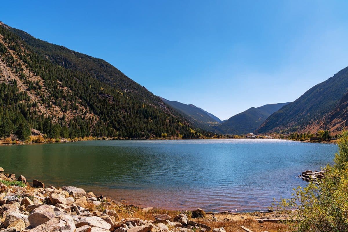 Georgetown Lake beneath steep forested mountains on a clear autumn day.