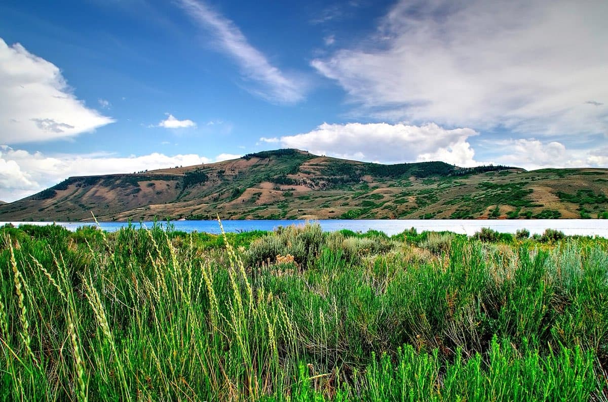 Blue Mesa Reservoir stretching beneath partly cloudy mountain skies.