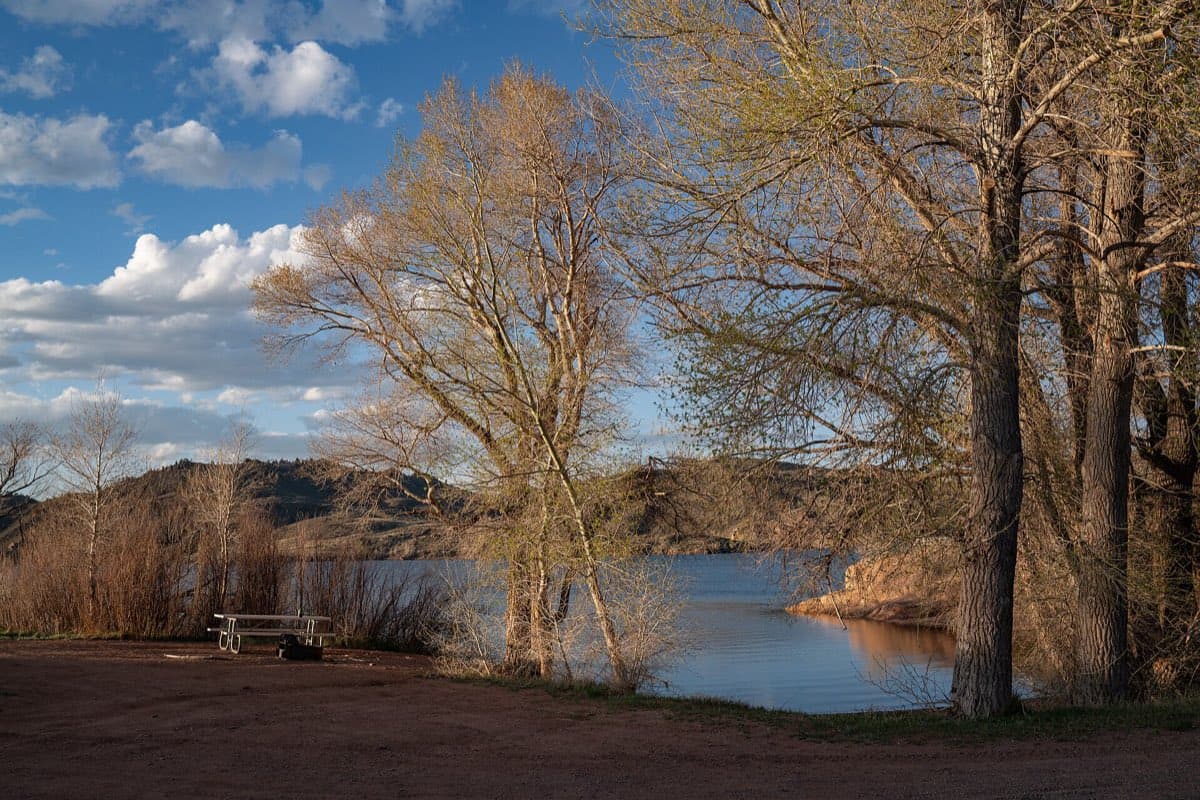 A picnic table at Monte Cristo Campground overlooking Crystal Lake Reservoir in Curt Gowdy State Park.