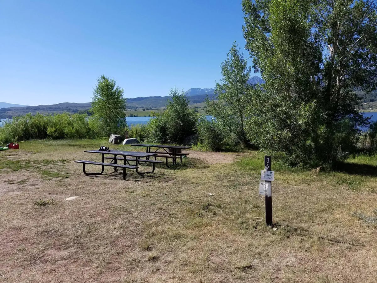 Two picnic tables at a lakeside campsite in Cow Creek South Campground