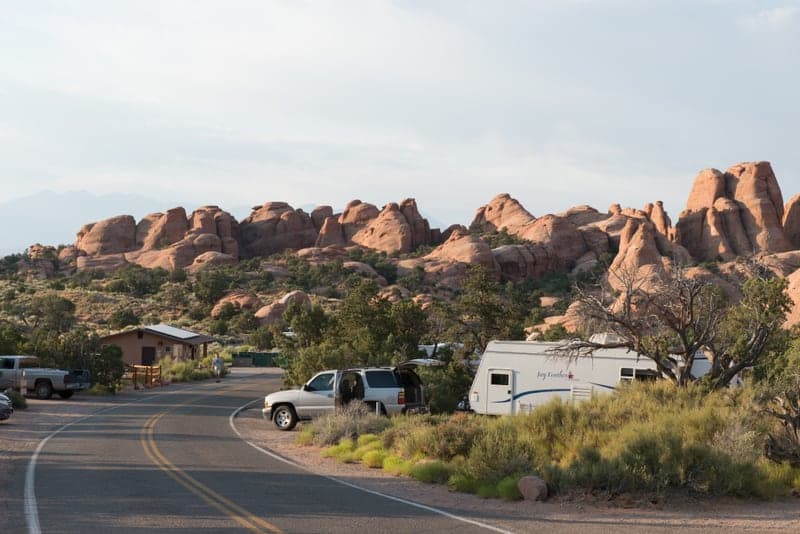 Campsites and RVs at Devils Garden Campground beneath sandstone fins in Arches National Park
