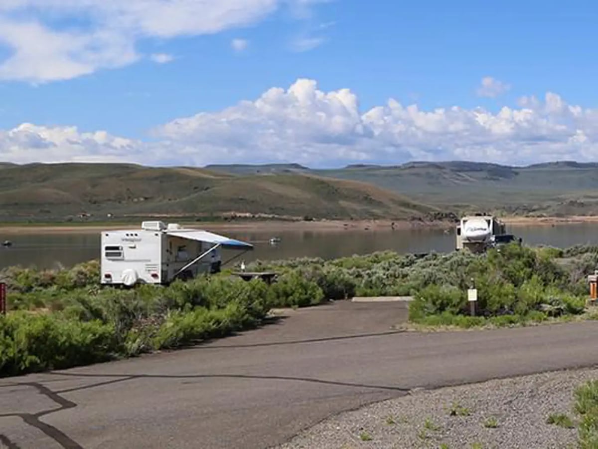 Lakeside campsites and RVs at Stevens Creek Campground beneath a broad blue sky