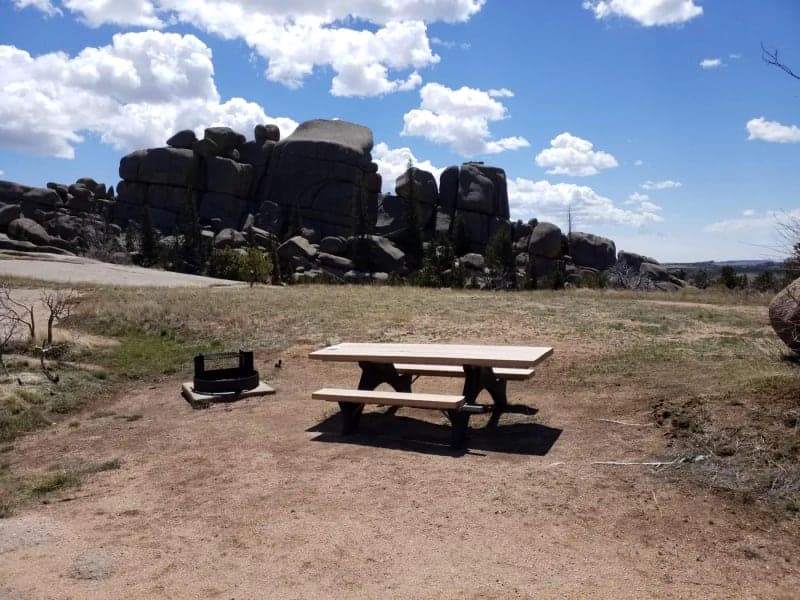 Picnic table and fire ring below granite formations at Vedauwoo Campground