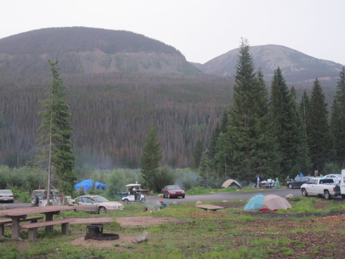 Tents and campsites below mountain slopes at Timber Creek Campground