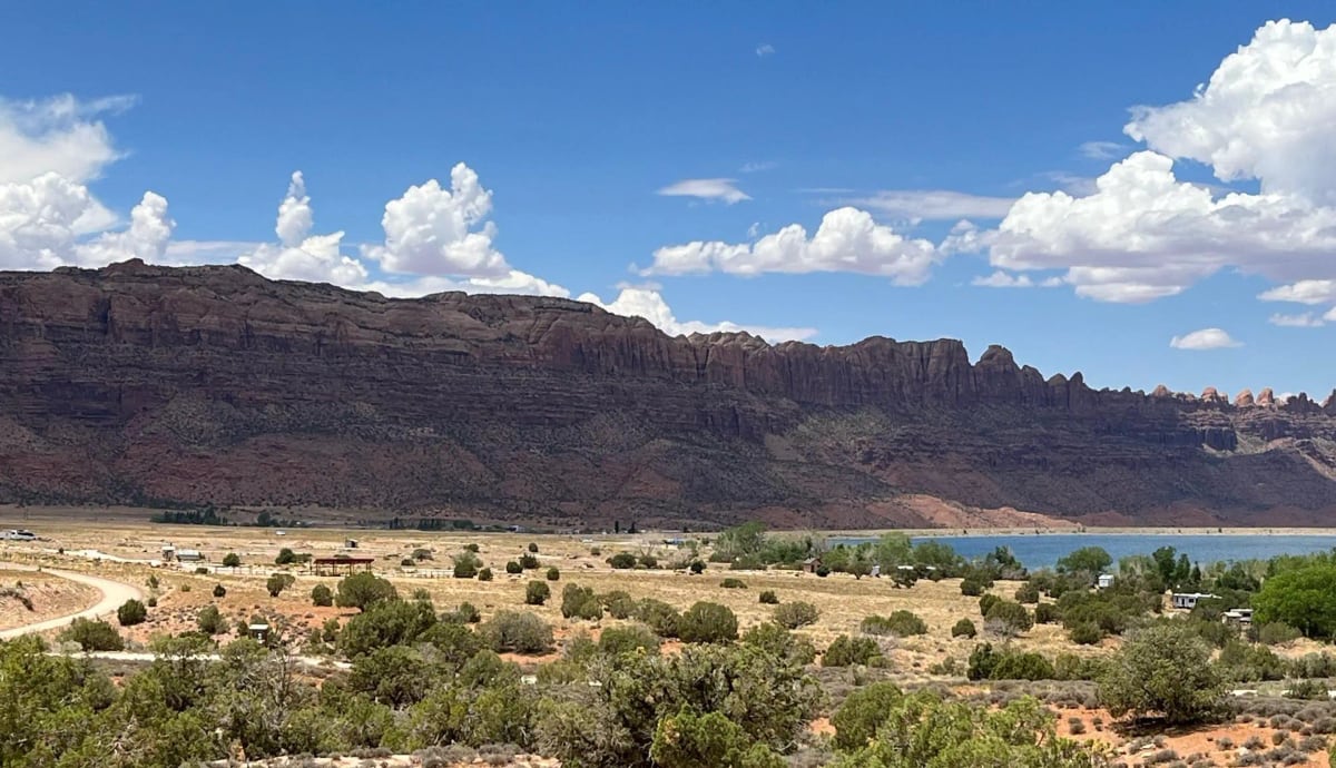 Overview of Ken's Lake Campground below red-rock cliffs and summer clouds