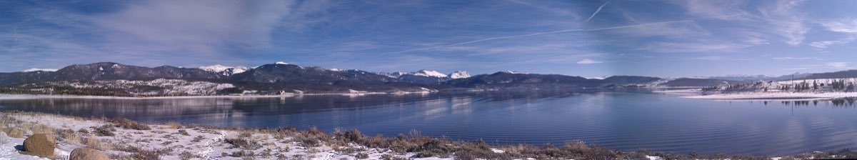 Lake Granby reflecting forested mountain ridges above a lightly snow-covered shore.