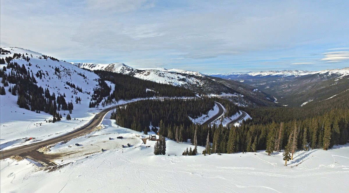 Snow-covered slopes and the winding US 40 corridor descending from Berthoud Pass into the Fraser Valley.